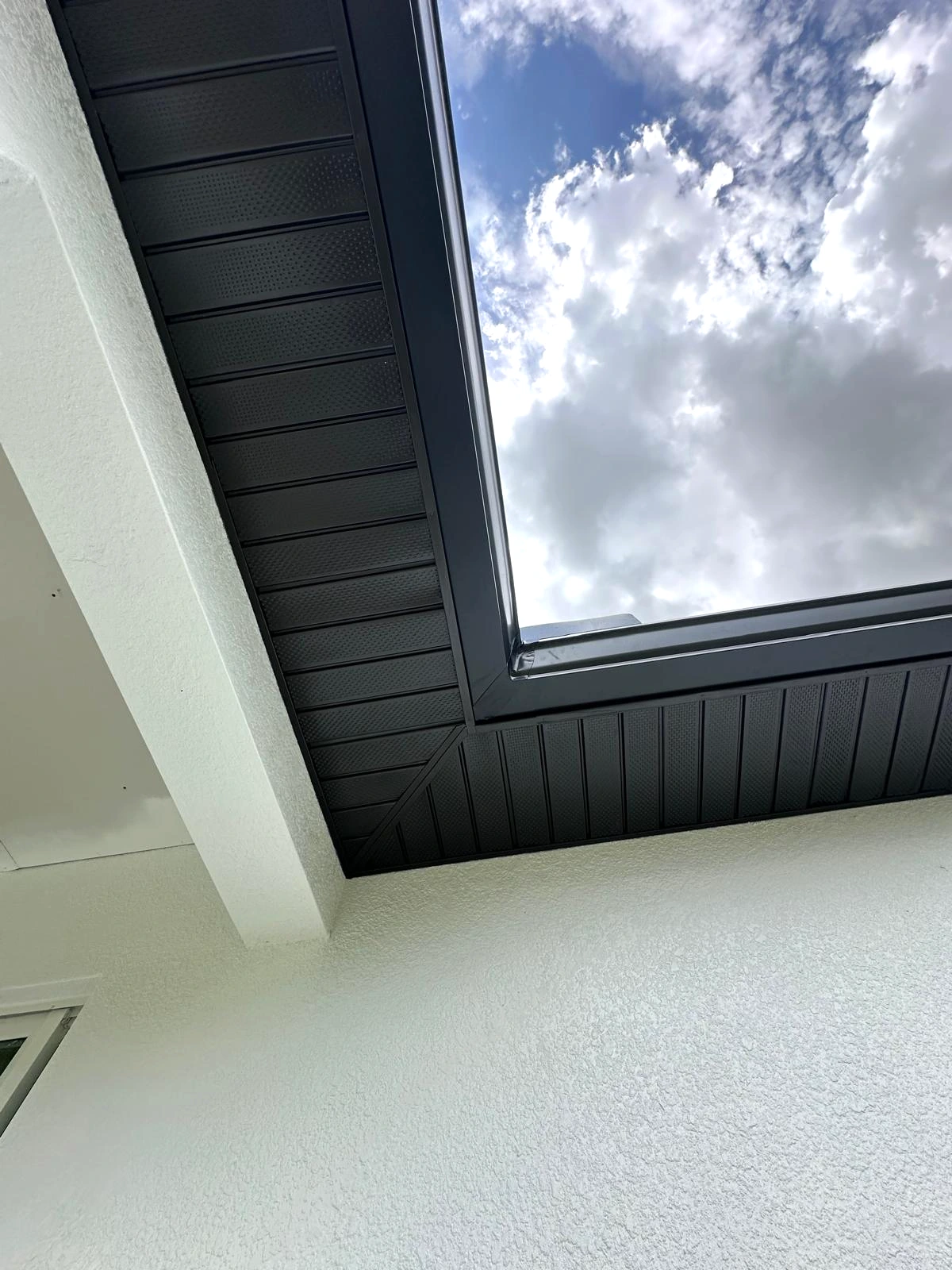 Dark vented soffit and fascia at a roof corner